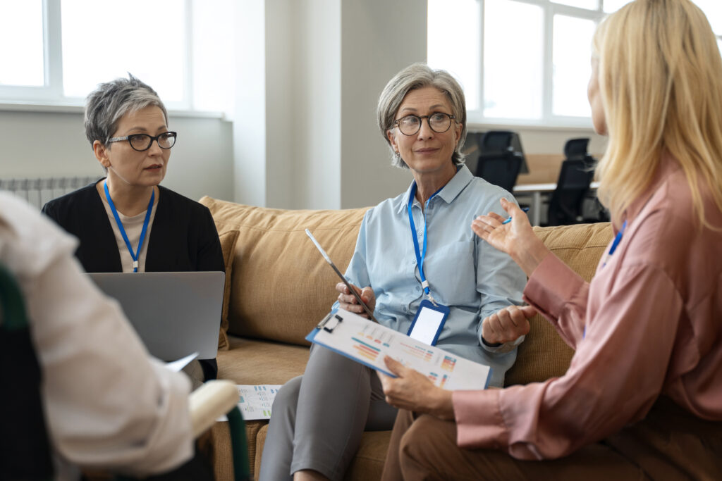 A professional with her clients having a focused conversation in a bright office setting.